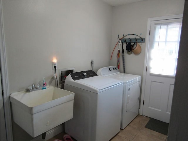 laundry room featuring sink, light tile patterned flooring, and separate washer and dryer