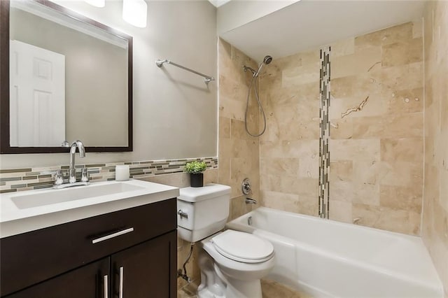 full bathroom featuring toilet, tiled shower / bath combo, vanity, and backsplash