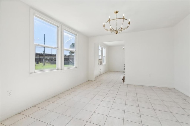 tiled empty room featuring a chandelier