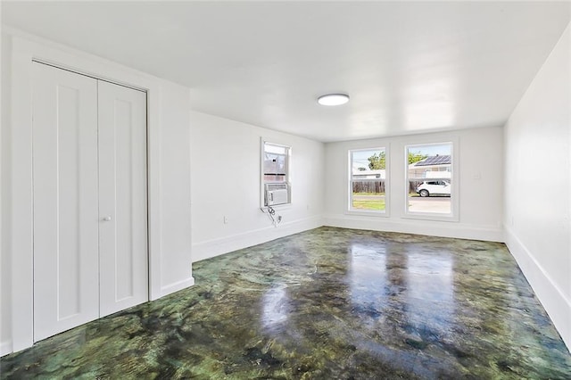 unfurnished bedroom with concrete flooring and a closet