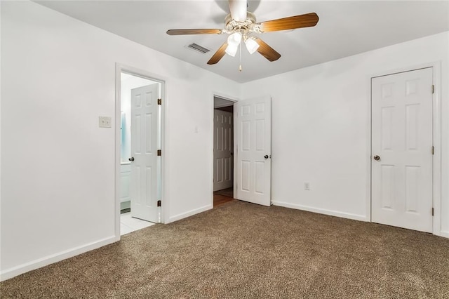 unfurnished bedroom with ensuite bathroom, light colored carpet, and ceiling fan