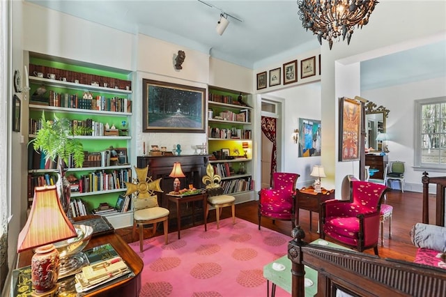 living area with a notable chandelier, hardwood / wood-style floors, and track lighting