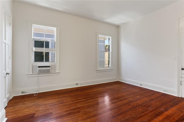 spare room featuring cooling unit and dark wood-type flooring