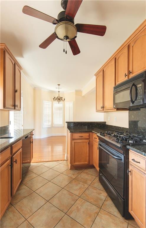 kitchen with hanging light fixtures, tasteful backsplash, light tile patterned floors, black appliances, and ceiling fan with notable chandelier