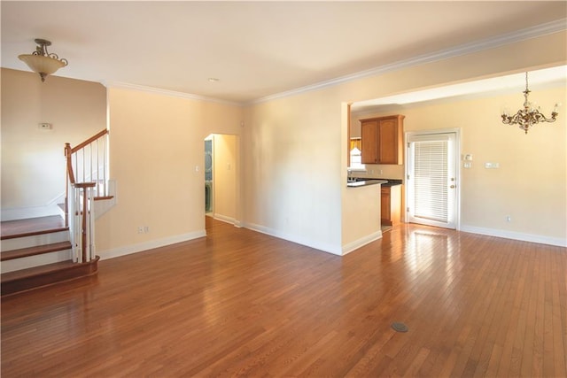 unfurnished living room with dark wood-type flooring, a notable chandelier, and ornamental molding