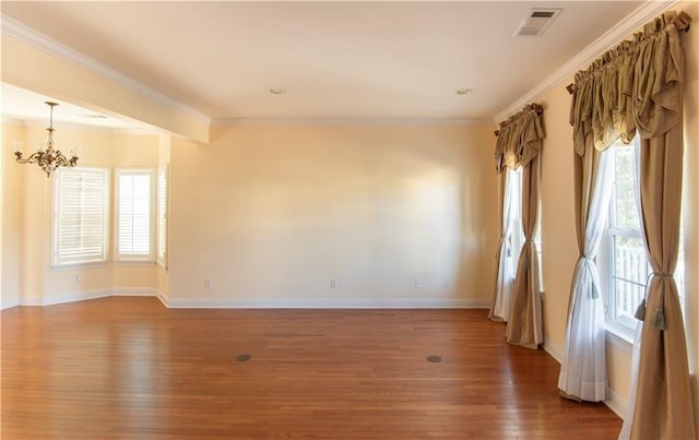 empty room featuring ornamental molding, dark wood-type flooring, and a notable chandelier