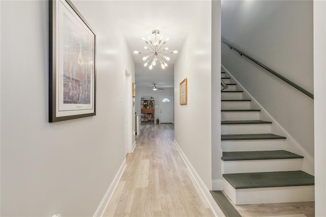 corridor featuring light hardwood / wood-style flooring and an inviting chandelier