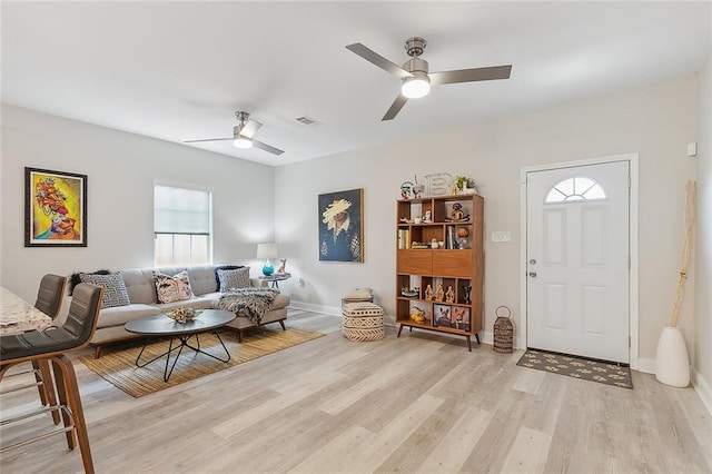 living room with light hardwood / wood-style floors and ceiling fan