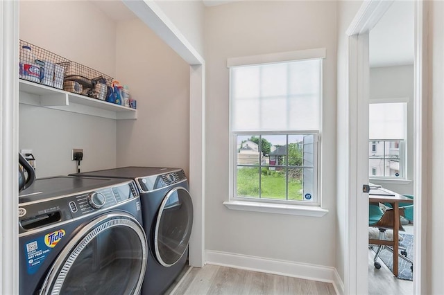 laundry area featuring light hardwood / wood-style flooring and washer and clothes dryer