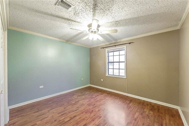 spare room with ceiling fan, a textured ceiling, ornamental molding, and hardwood / wood-style floors