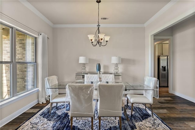 dining area with ornamental molding, dark wood-type flooring, and an inviting chandelier