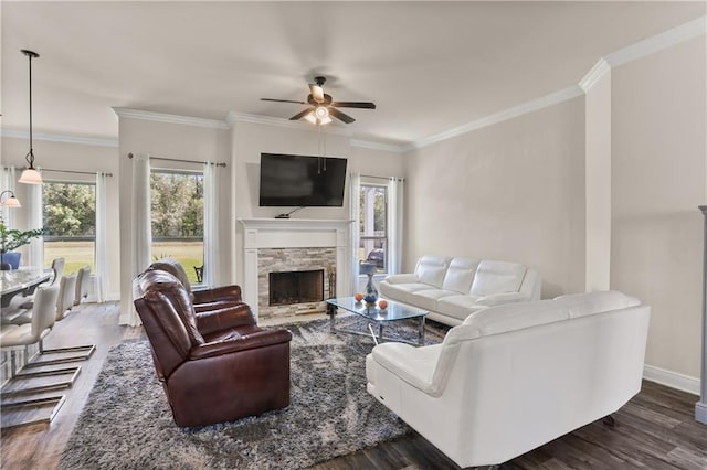 living room featuring crown molding, dark hardwood / wood-style floors, a fireplace, and ceiling fan