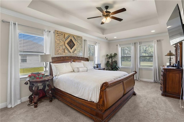 carpeted bedroom featuring ceiling fan, a raised ceiling, and crown molding