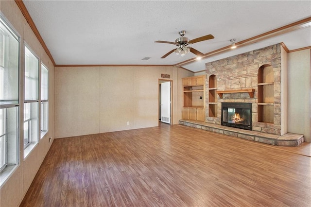 unfurnished living room with vaulted ceiling, a fireplace, wood-type flooring, and plenty of natural light