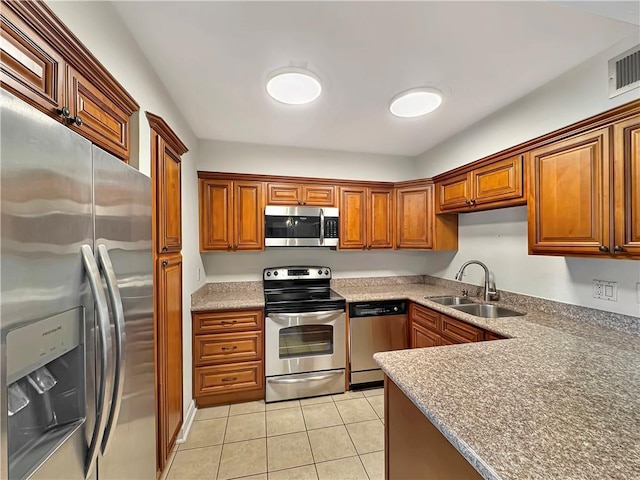 kitchen with stainless steel appliances, light tile patterned flooring, and sink