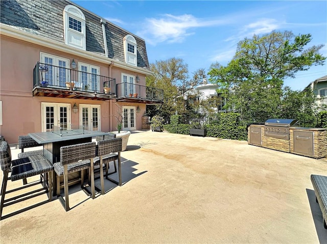 view of patio with area for grilling, an outdoor kitchen, an outdoor bar, and french doors