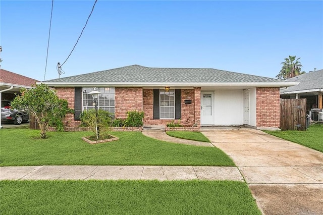 ranch-style home featuring a front lawn and a carport