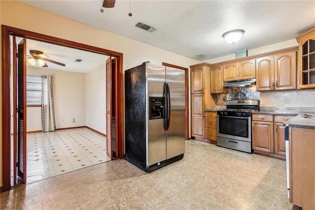 kitchen with appliances with stainless steel finishes, light tile patterned flooring, backsplash, and ceiling fan