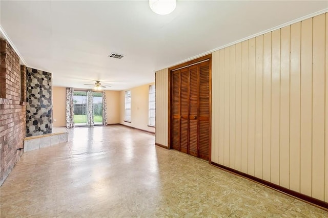 spare room with ceiling fan and wooden walls