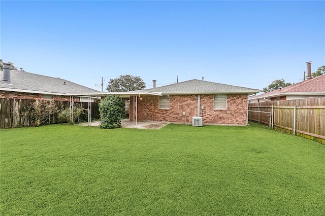 rear view of house featuring a yard, central air condition unit, and a patio