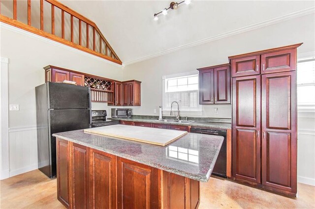 kitchen with a kitchen island, high vaulted ceiling, black appliances, stone counters, and sink