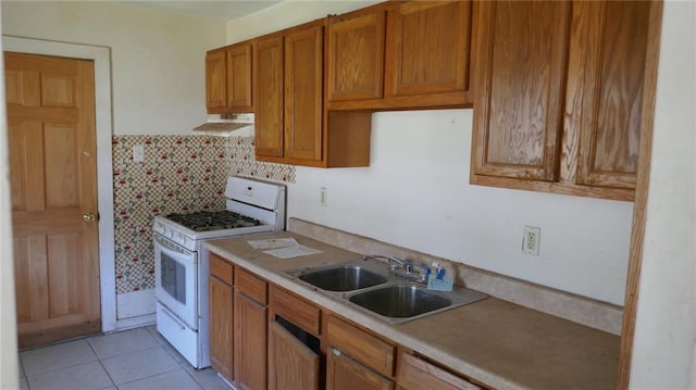 kitchen featuring light tile patterned flooring, sink, backsplash, white gas range, and ventilation hood