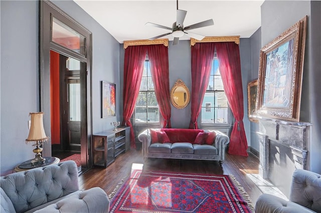 living area with ceiling fan and dark hardwood / wood-style flooring