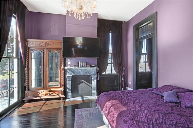 bedroom with a notable chandelier, multiple windows, and hardwood / wood-style floors