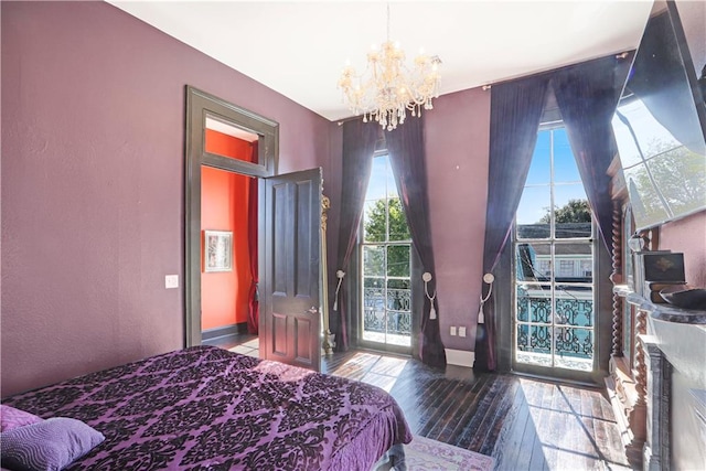 bedroom featuring an inviting chandelier, multiple windows, and wood-type flooring