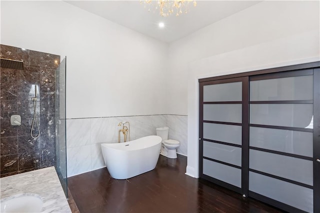 full bathroom with shower with separate bathtub, hardwood / wood-style floors, toilet, tile walls, and vanity