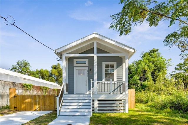 5017 N Miro St, New Orleans, LA 70117 - shotgun-style home featuring stairway, a porch, and fence