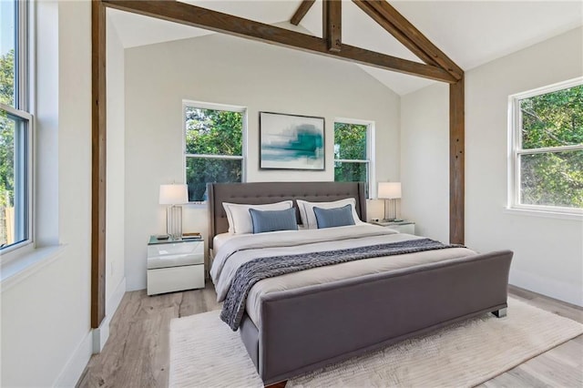 bedroom with light hardwood / wood-style floors, lofted ceiling with beams, and multiple windows