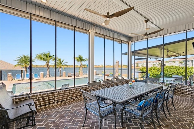 sunroom featuring ceiling fan, a water view, and a wealth of natural light