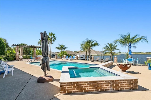 view of pool with a water view, a patio area, and an in ground hot tub