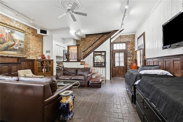 bedroom with crown molding, brick wall, track lighting, and wooden walls