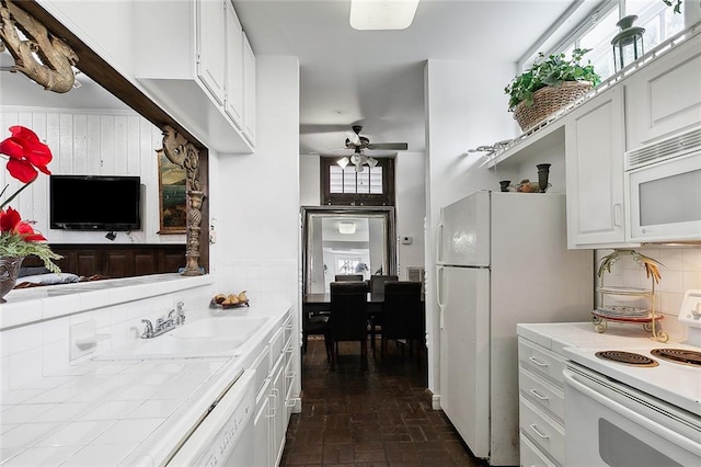 kitchen with ceiling fan, backsplash, white cabinetry, sink, and white appliances