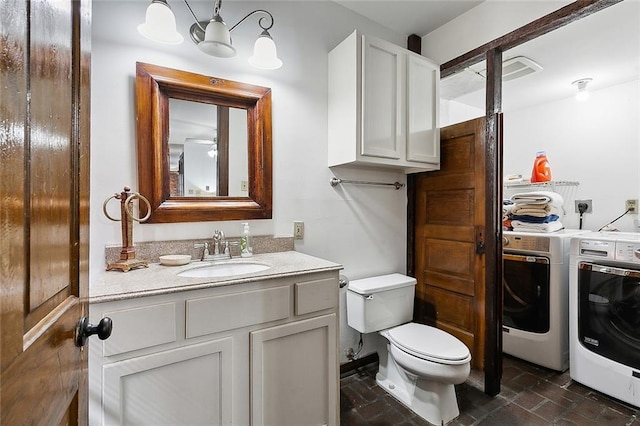 bathroom with vanity, toilet, and washing machine and dryer