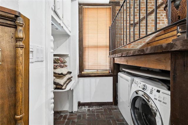 clothes washing area featuring cabinets and washer and clothes dryer