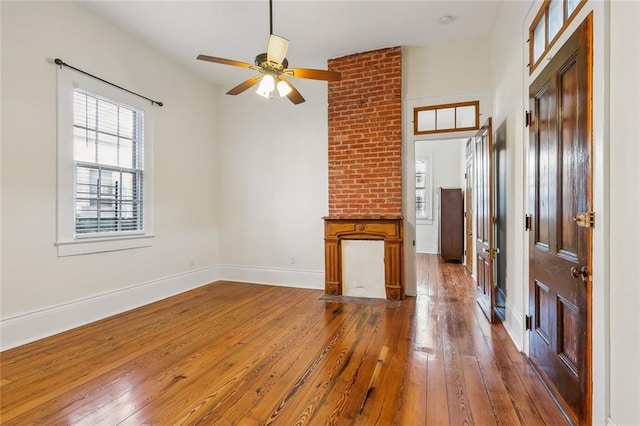 unfurnished living room with ceiling fan and dark hardwood / wood-style flooring