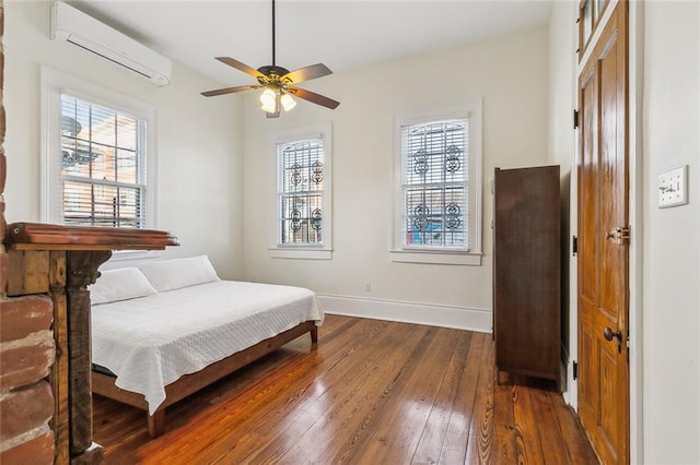 bedroom featuring dark wood-type flooring, ceiling fan, and a wall mounted AC