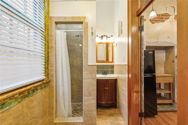 bathroom featuring vanity, tile walls, hardwood / wood-style flooring, and a shower with shower curtain