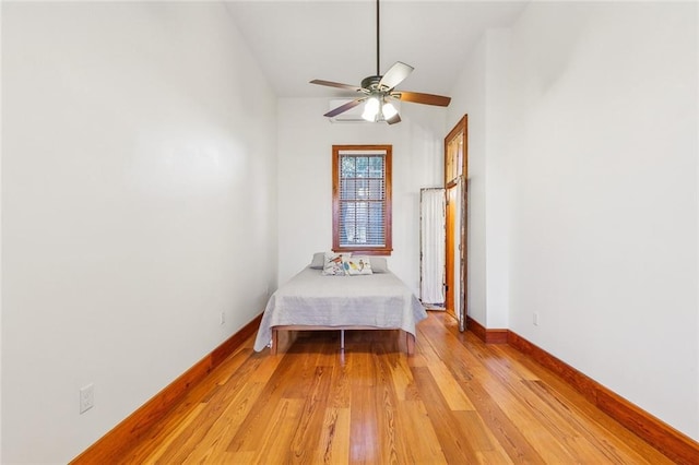 unfurnished bedroom featuring ceiling fan, vaulted ceiling, and light hardwood / wood-style flooring