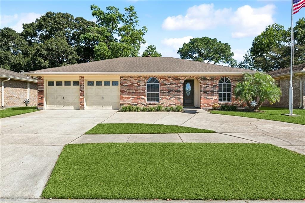 ranch-style home with a front yard and a garage