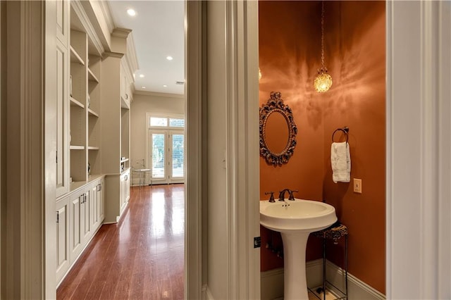 bathroom featuring wood-type flooring and crown molding