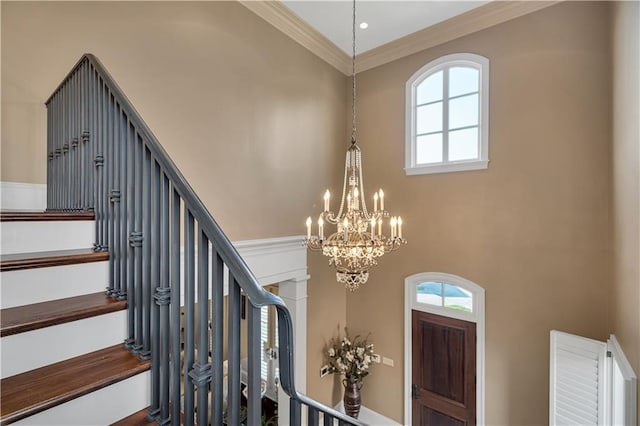 foyer entrance featuring a high ceiling, ornamental molding, and plenty of natural light