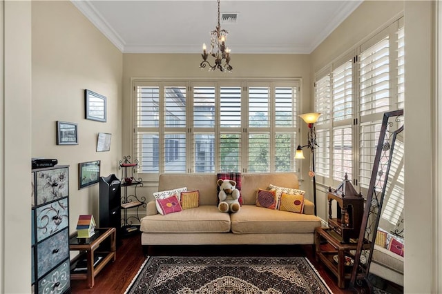 sitting room with ornamental molding, dark hardwood / wood-style flooring, and an inviting chandelier