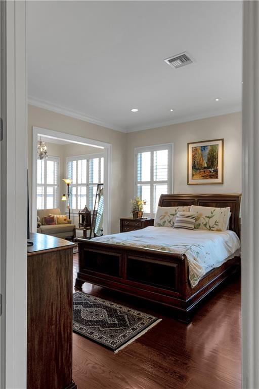 bedroom with hardwood / wood-style flooring, multiple windows, and crown molding