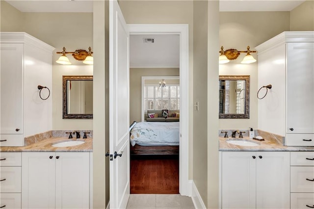 bathroom with wood-type flooring, vanity, crown molding, and a notable chandelier