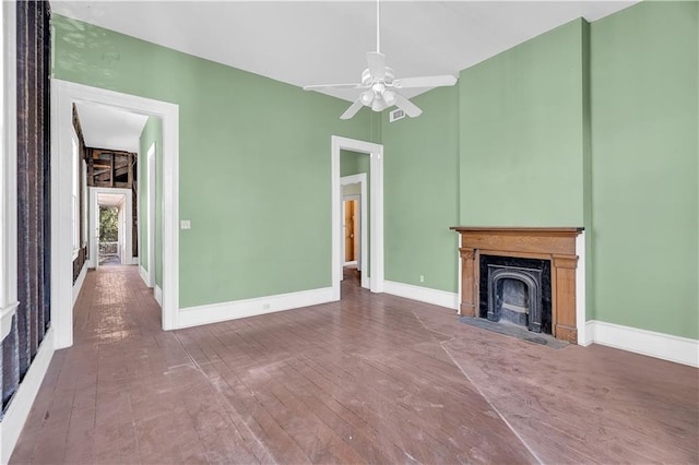 unfurnished living room with ceiling fan, hardwood / wood-style flooring, and a high end fireplace