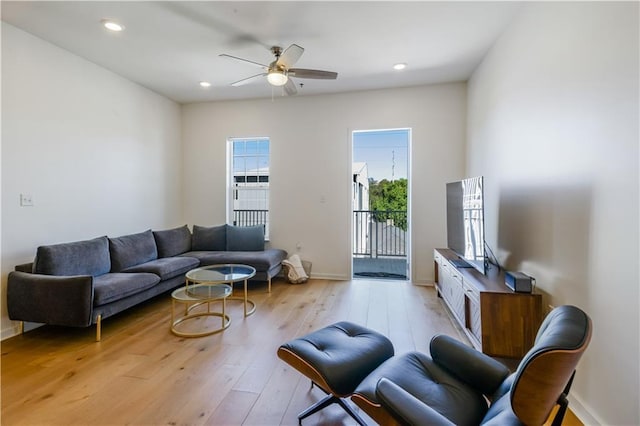 living room with a ceiling fan, light wood-style flooring, recessed lighting, and baseboards